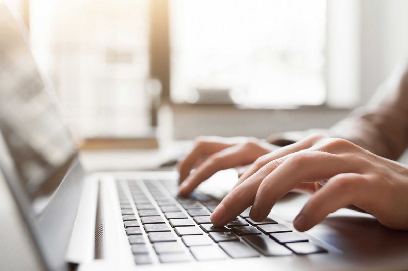 Hände tippen auf Laptoptastatur